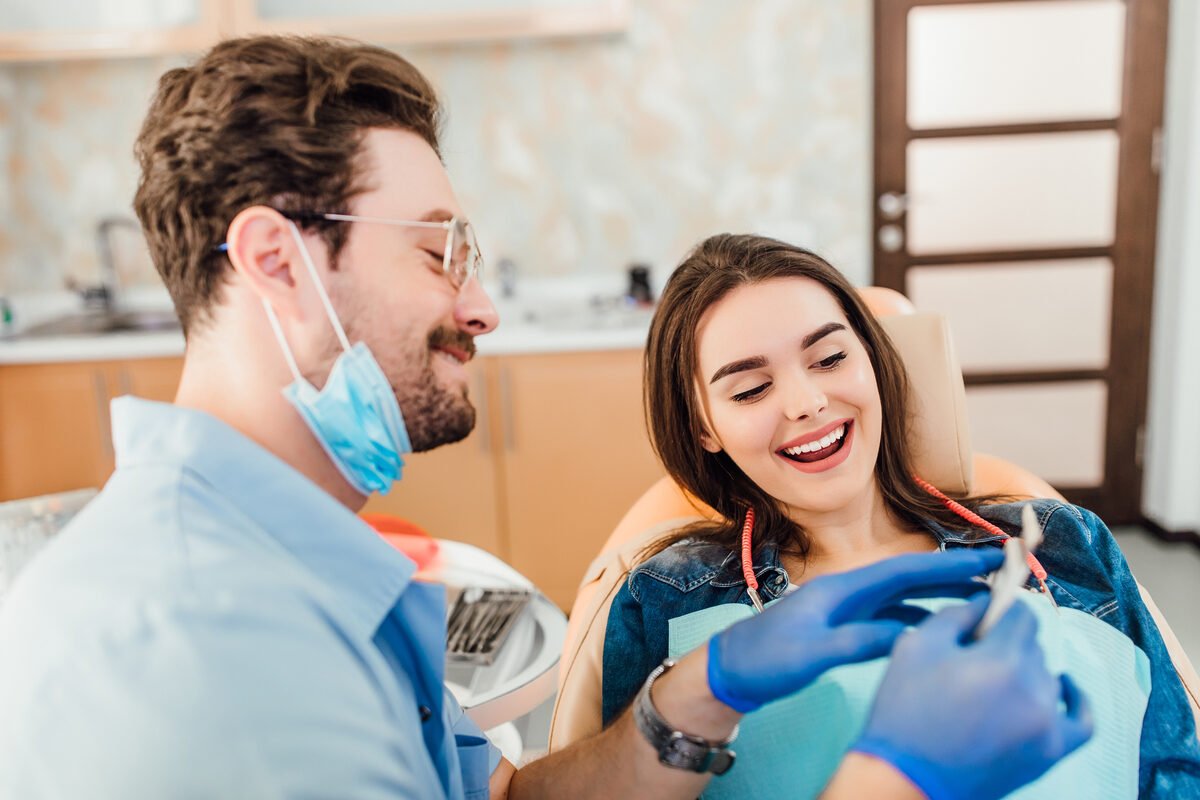 Example ad photo: a dentist showing a smiling patient a tooth shade guide